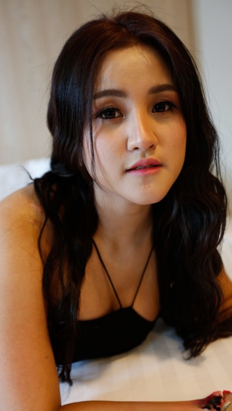 Beautiful Asian girl Zin shows her big tits while undressing for POV sex